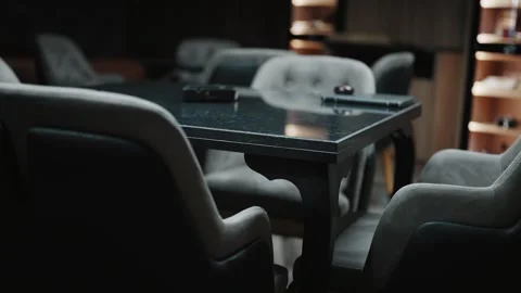 Cozy luxury seating area featuring table and chairs in a dimly lit interior Stock Footage 323393638