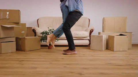 In a cozy, newly moved-in space filled with cardboard boxes, a barefoot couple Stock Footage 283978094