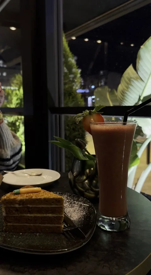 Cozy Night Café Table with Coffee, Strawberry Juice, and Carrot Cheesecake Video stock 320296080