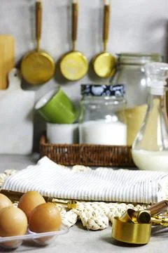 A cozy, organized kitchen setting featuring eggs, a milk bottle, glass jars, cop Stock Photos