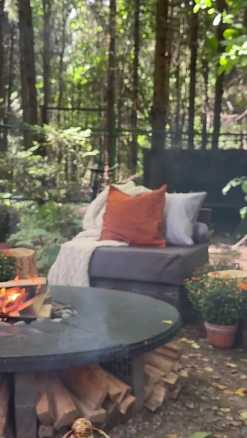 Cozy outdoor fire pit area decorated for autumn in a woodland garden 스톡 동영상 342647775