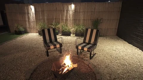 Cozy Outdoor Fire Pit with Striped Garden Chairs at Night in Mendoza, Argentina Stock Footage 340150583