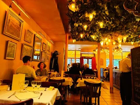 Cozy Paris bistro interior with diners and warm lighting, intimate dining s.. Stock Photos