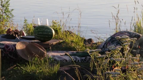 Cozy Picnic Setup by Lake with Campfire and Wine at Sunset Stock Footage 332307588