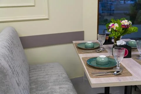Cozy restaurant interior with table setting Stock Photos