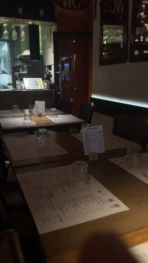 Cozy restaurant interior with table settings and warm focused lighting during Видео 344584932