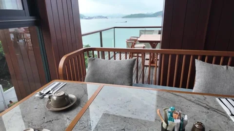 Cozy restaurant table seating with a scenic view of the calm ocean and islands Video stock 343390603