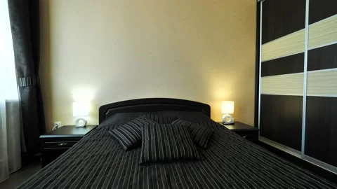 Cozy room with large bed and wardrobe in dark tones Stock Footage 164463151