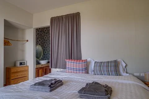 Cozy rustic bedroom with comfortable bed and wooden furniture 스톡 사진