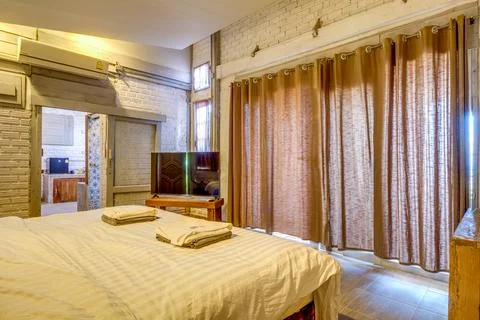 Cozy rustic bedroom with comfortable bed and wooden furniture Фото