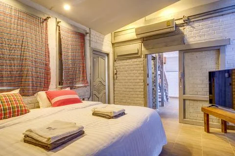 Cozy rustic bedroom with comfortable bed and wooden furniture Photos