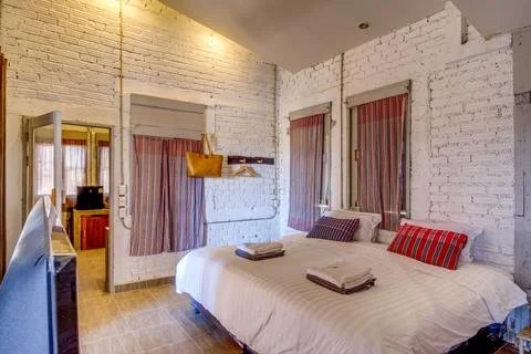Cozy rustic bedroom with comfortable bed and wooden furniture Foto stock