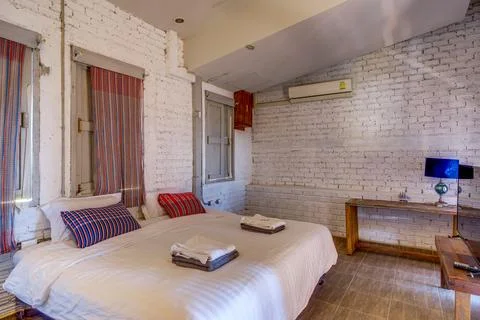 Cozy rustic bedroom with comfortable bed and wooden furniture 写真素材