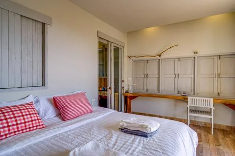 Cozy rustic bedroom with comfortable bed and wooden furniture Fotos Stock
