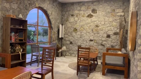 Cozy Rustic Cafe Interior with Exposed Stone Wall and Arched Window View Stock Footage 318569274