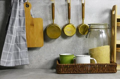 Cozy Rustic Kitchen Scene With Cutting Board, Hanging Pots, Mugs, And Grain Jar  Stock Photos