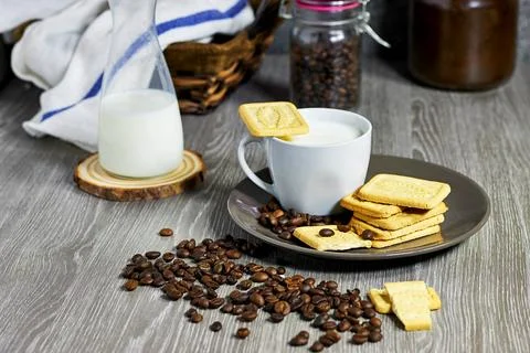 Cozy Rustic Setting with Coffee, Milk, and Biscuits on Wooden Table Stock Photos