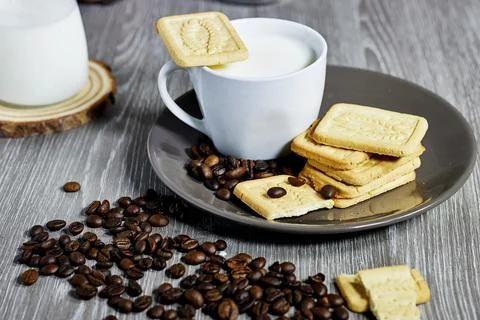 Cozy Rustic Setting with Coffee, Milk, and Biscuits on Wooden Table Stock Photos