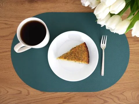 Cozy scene featuring a cup of coffee, poppy seeds, and vibrant tulips. Stock Photos