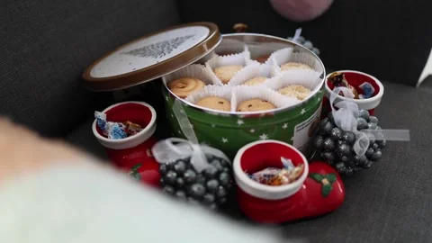 A cozy scene featuring a tin of assorted Danish butter cookies in a festive gree Video stock 294704867