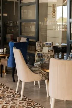 Cozy seating area features a mix of colorful and patterned chairs. Large wind Stock Photos