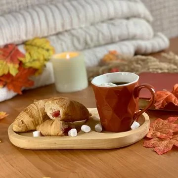 A cozy setup featuring a cup of hot coffee alongside croissants and marshmallows Foto stock