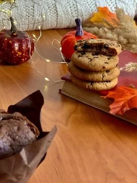A cozy setup showcases a stack of chocolate chip cookies next to a book, Foto stock