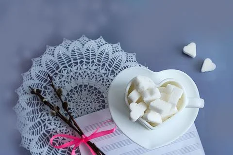 Cozy spring: a cup with pieces of sugar on an openwork napkin, next to a sp.. Stock Photos