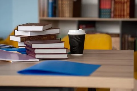 A Cozy Study Space Featuring Stacks of Books, Colorful Papers, and a Takeaw.. Stock Photos