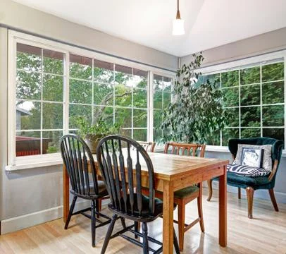 Cozy summer room with dining table set, vintage green velvet armchair near th Stock Photos