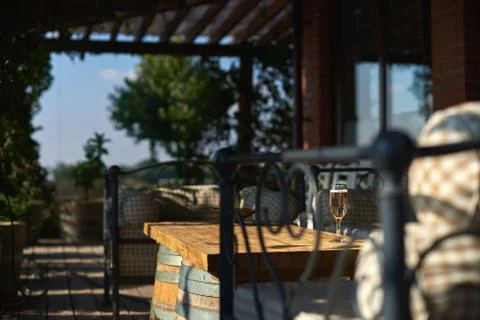 Cozy terrace with sofas for rest, Glass with champagne on a wooden table. Stock Photos