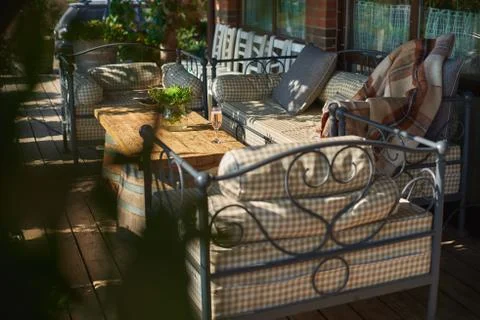 Cozy terrace with sofas for rest, Glass with champagne on a wooden table. Stock Photos