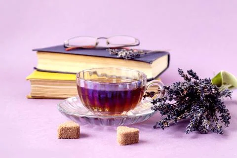 Cozy time over a cup of tea: a cup of tea with a dry bouquet of lavender agai Stock Photos