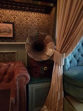 Cozy Victorian Parlour with Leather Sofas, Blue Chairs, and Gramophone Stock Photos