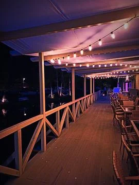 Cozy waterfront deck with string lights Stock Photos