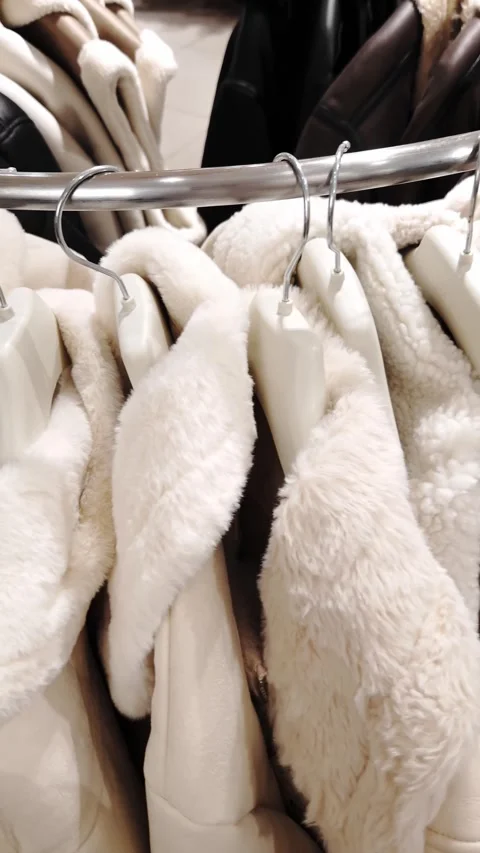 Cozy White Shearling Jackets Hanging on a Retail Clothing Rack Stock-Footage 325224669