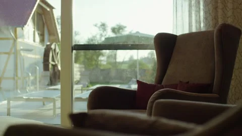 Cozy Wingback Armchair by Large Window, Sunlit Terrace View, Interior Scene Vídeo Stock 341431452