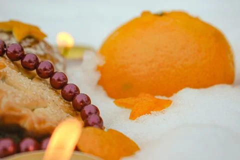 Cozy winter composition with mandarin beads and citrus stars on snow Stock Photos