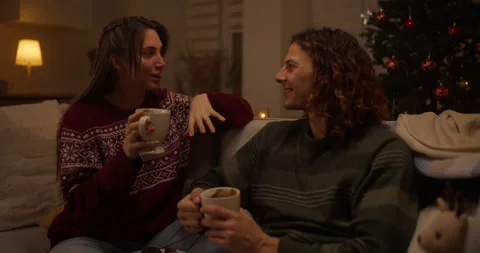 Cozy winter evening with warm drinks and holiday atmosphere shared by friends at Stock Footage 318040142
