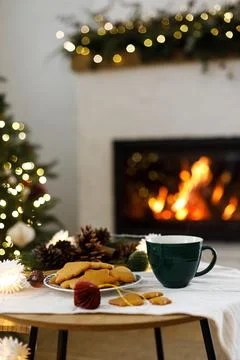 Cozy winter holiday setup featuring gingerbread cookies, mug, and pine cones Stock Photos