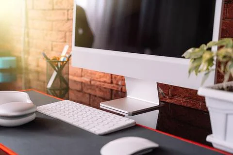 Cozy workplace with a computer and wireless devices and a home plant against a Stock Photos