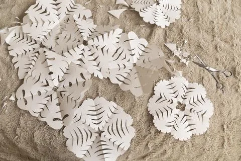 A cozy workspace showcases an array of white paper cutouts featuring intricat Stock Photos