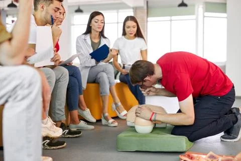 CPR class with caucasian instructors speaking and demonstrating help first aid 写真素材