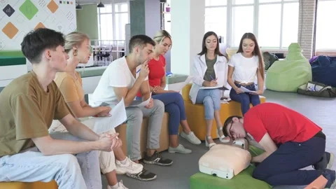 CPR class with male instructor speaking and demonstrating help, giving lessons Stock Footage 145453539