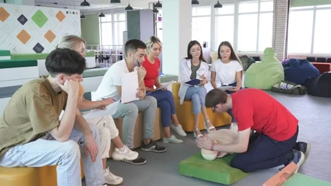 CPR class with young caucasian instructors speaking and demonstrating help first Stock Footage 144102408