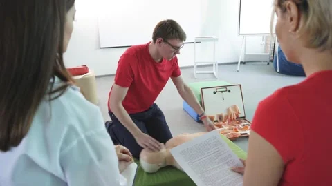 CPR class with young caucasian instructors speaking and demonstrating help first Stock Footage 144102758