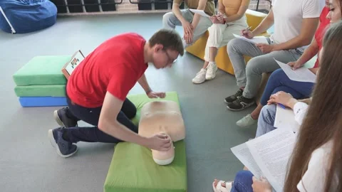 CPR class with young caucasian instructors speaking and demonstrating help first Stock Footage 146258452