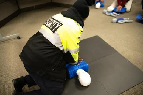 CPR training class by security guard in office Stock Photos