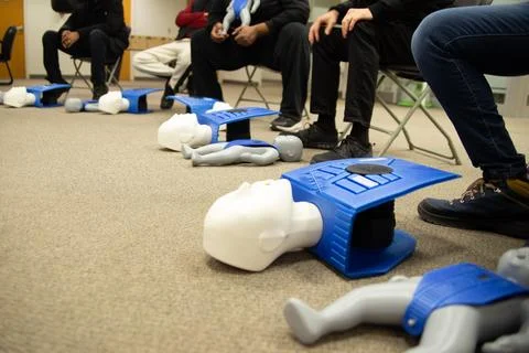 CPR training class by security guard in office Stock Photos