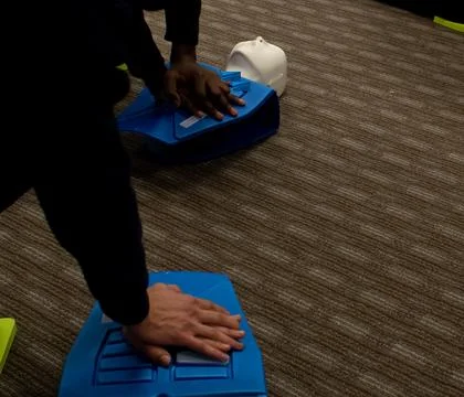 CPR training class by security guard in office Stock Photos